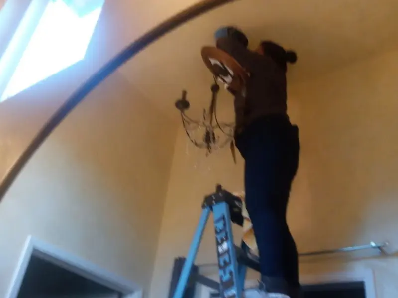 Electrician installing a chandelier in a Winfield residence